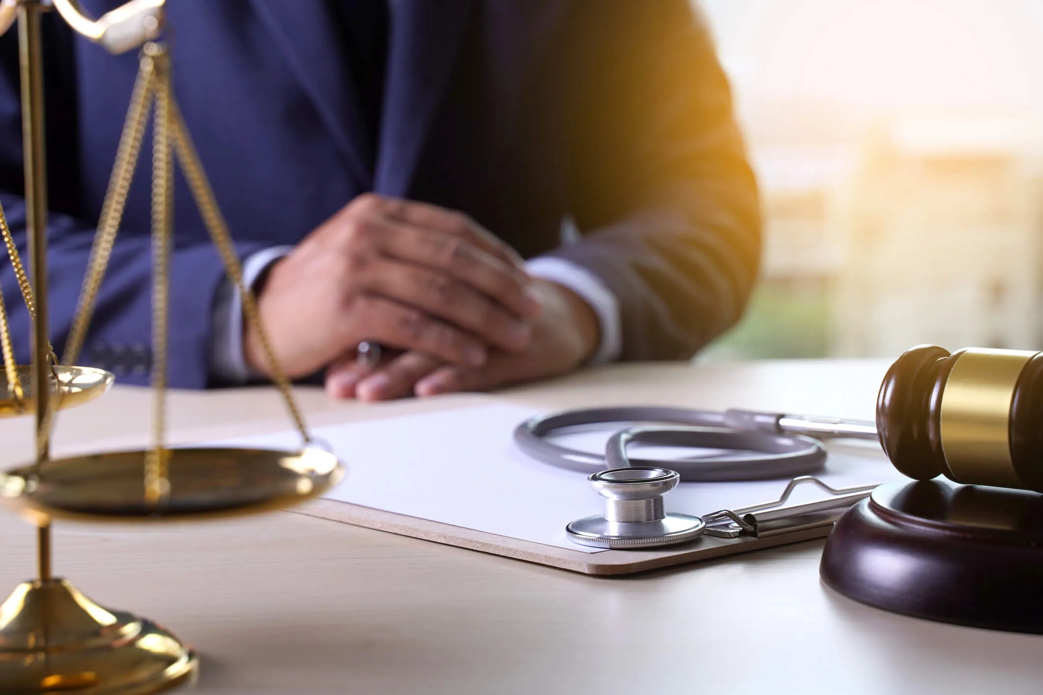 Doctor in handcuffs holding a stethoscope behind his back