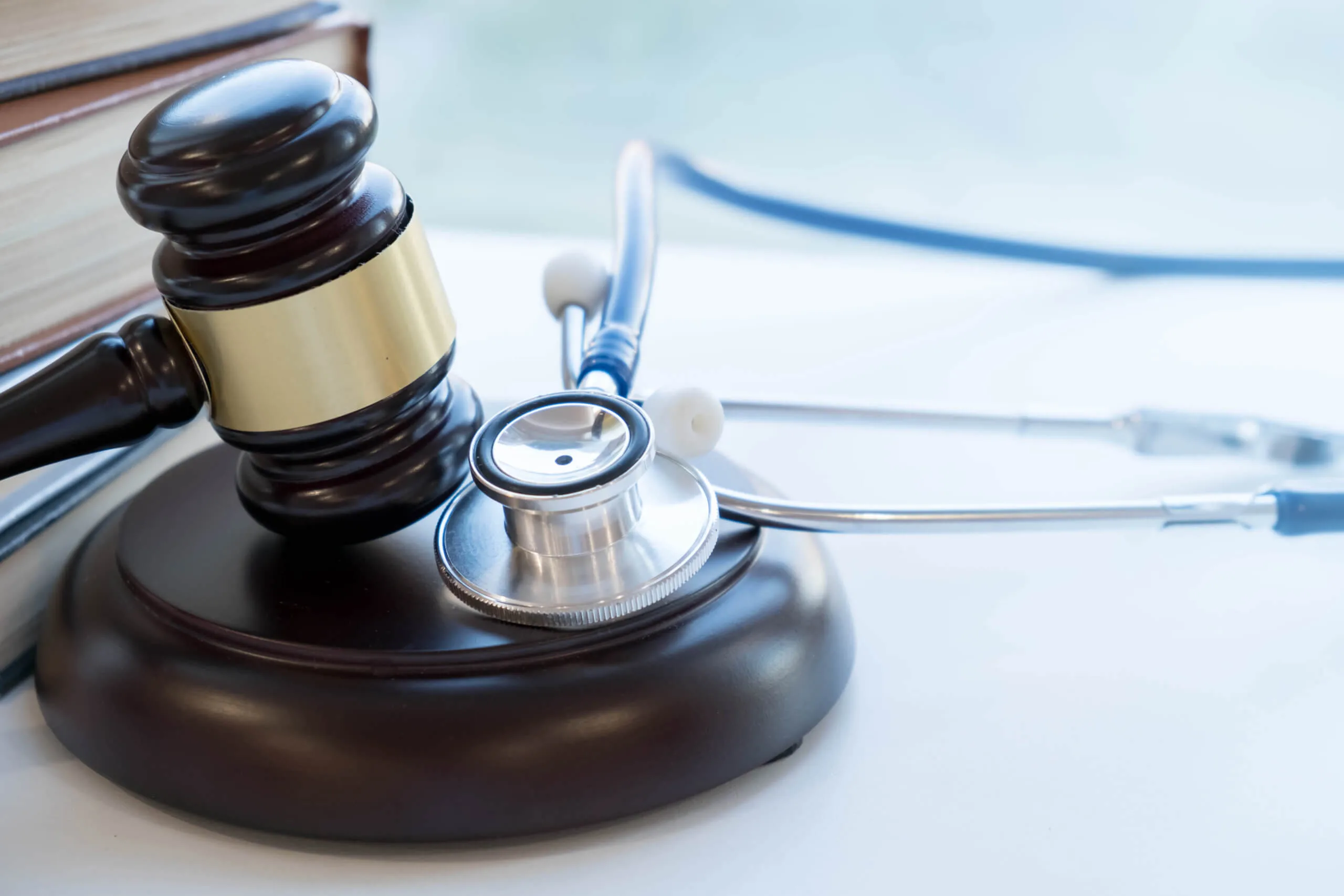 Judge’s gavel resting beside a stethoscope on desk