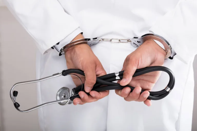 Doctor in handcuffs holding a stethoscope behind back