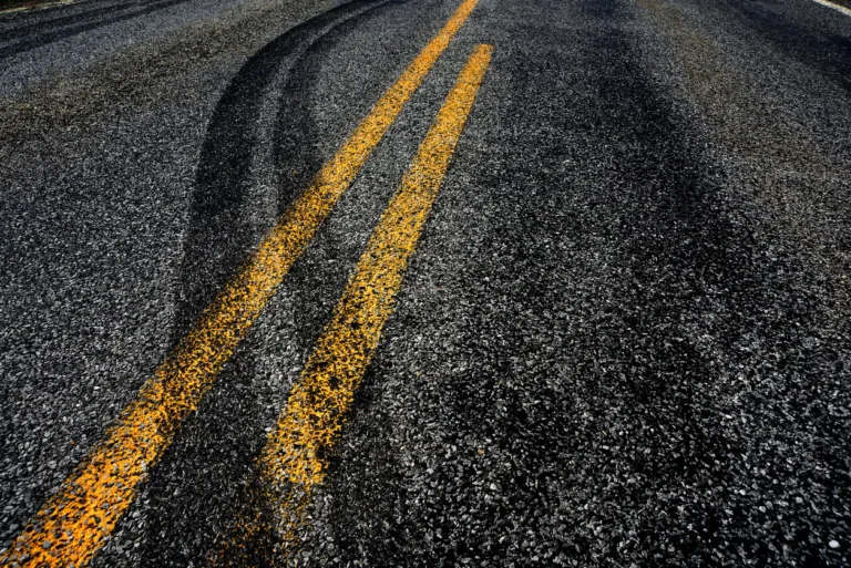 Skid marks across double yellow centerlines on asphalt road