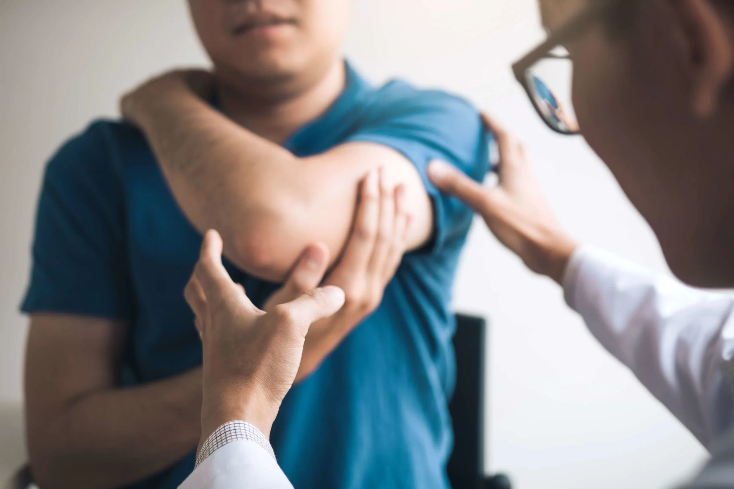 Doctor examining patient's injured elbow.