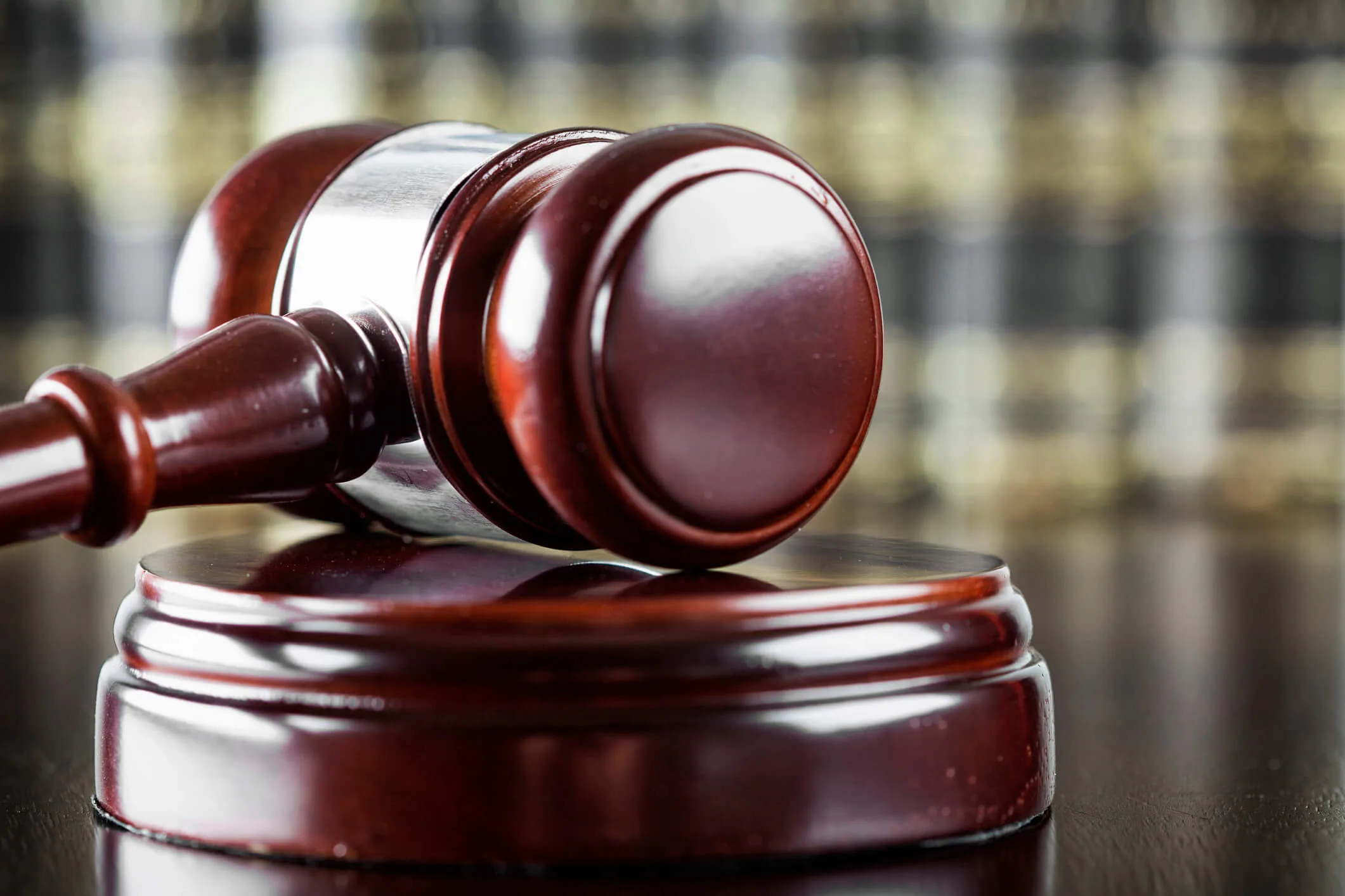 Close-up of a wooden judge’s gavel resting on its sound block