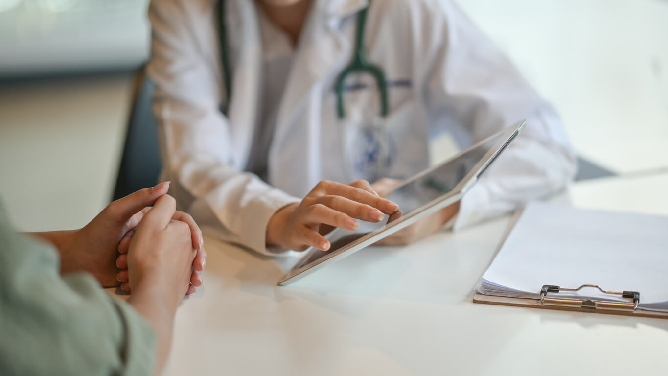 Person sitting with doctor discussing their car accident injuries