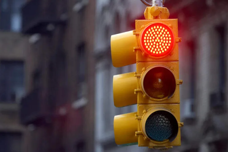 Close-up of red traffic light in a city street.