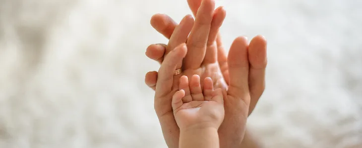 fathers hand holding mothers hand holding babys hand cystic fibrosis