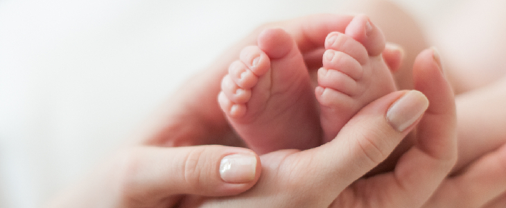 women holding a baby's feet with with familial dysautonomia