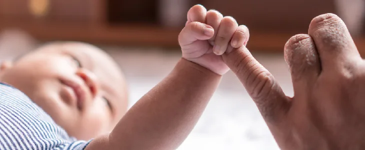 baby with sickle cell anemia grabbing a person's finger