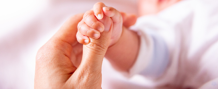 baby with trisomy 18 holding a person's hand