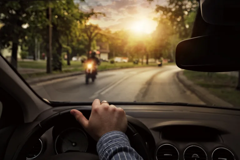 car driving behind a motorcycle