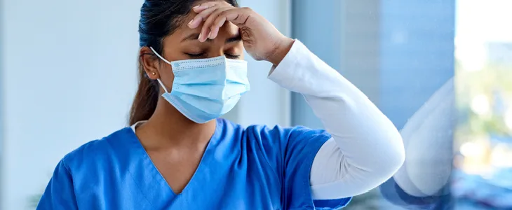 A female nurse, visibly stressed