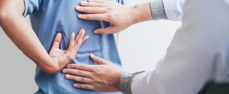 Doctor examining a patient's back pain