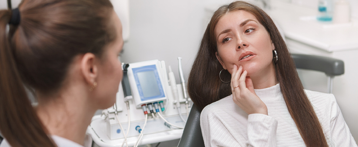 A woman in pain while visiting the orthodontist
