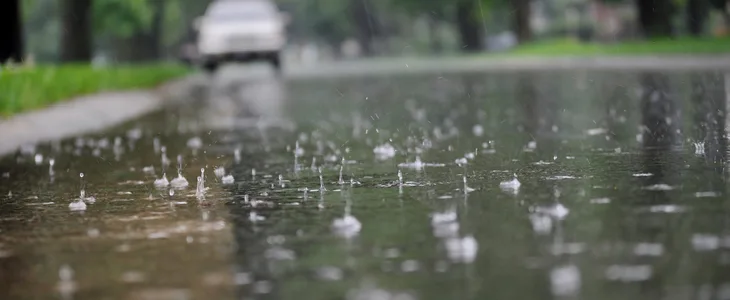 Close-up photo of a wet and slippery sidewalk on a rainy day