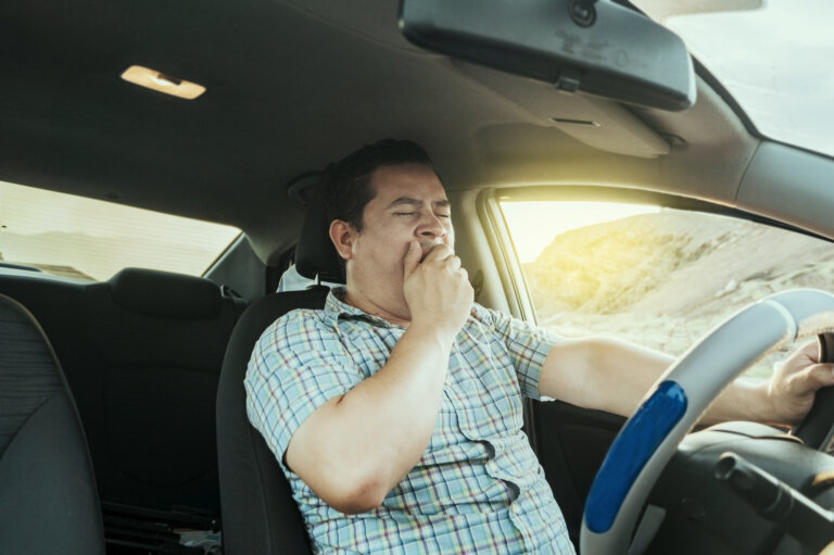 man driving and yawning
