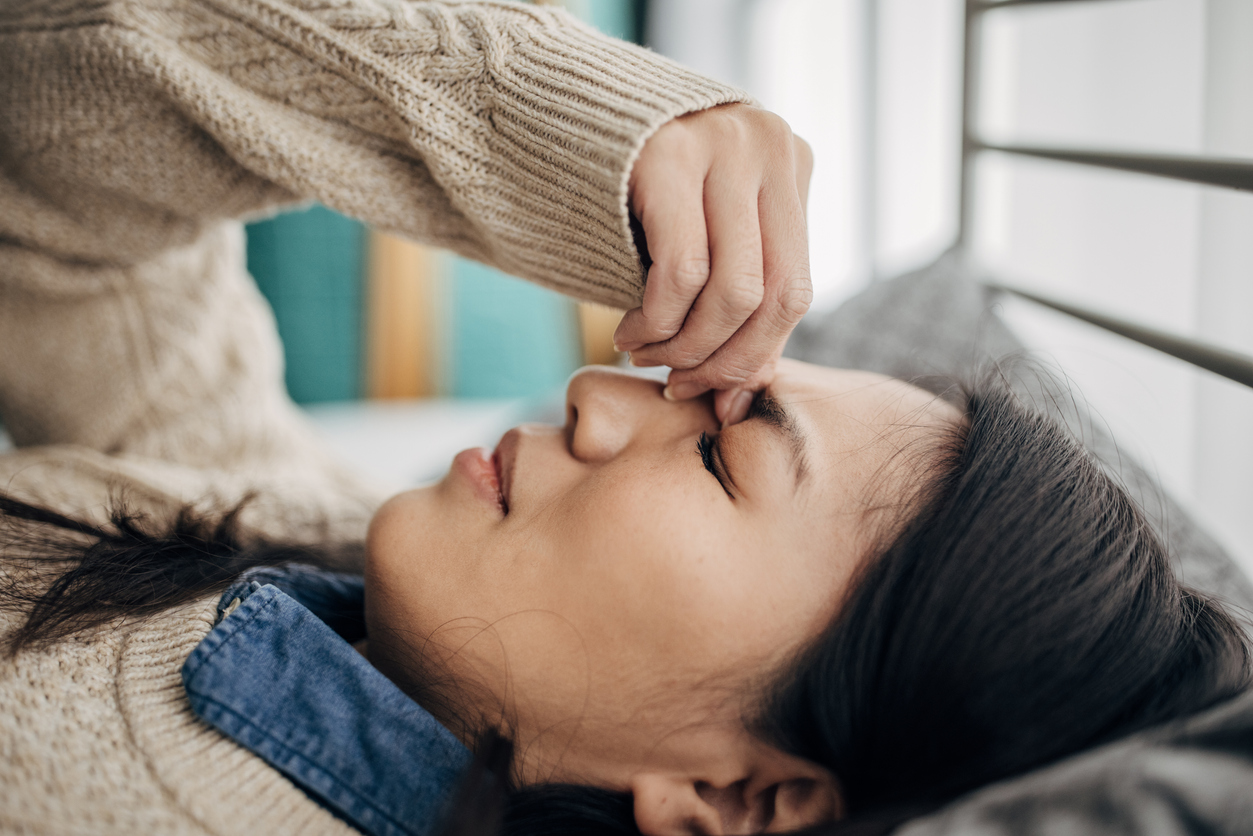 woman laying down with a headache