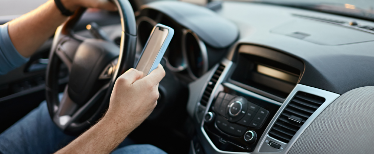 Man driving while texting on his phone