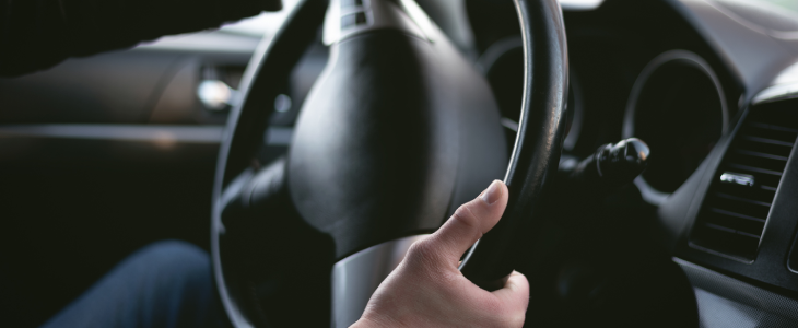 Driver turning the wheel of a car