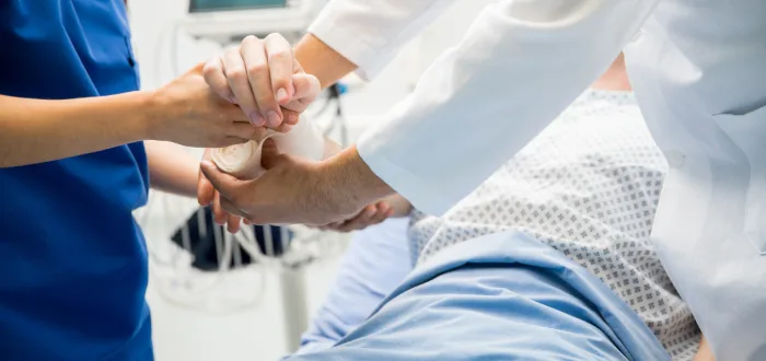 Lady with a severe burn getting protected by doctors