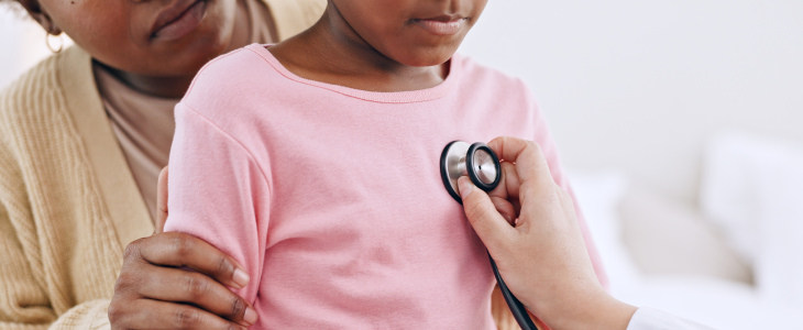 Pediatric doctor listening to young girls heart rate