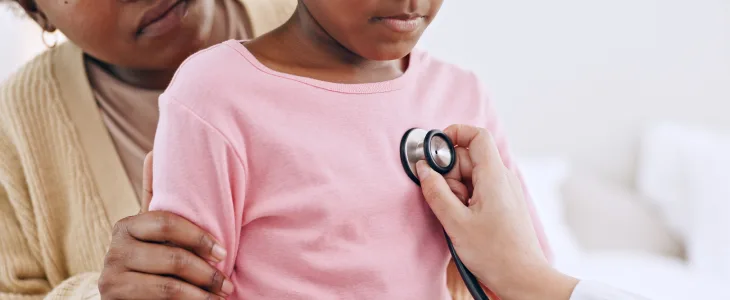 Pediatric doctor listening to young girls heart rate