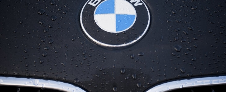 Circle shape BMW logo and part of the front grill on a black car.